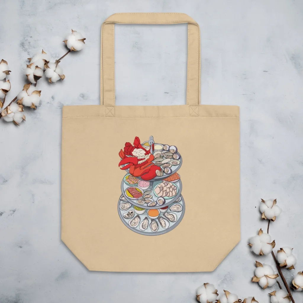 Beige tote bag features a colorful illustration of stacked seafood dishes, including lobster and oysters.